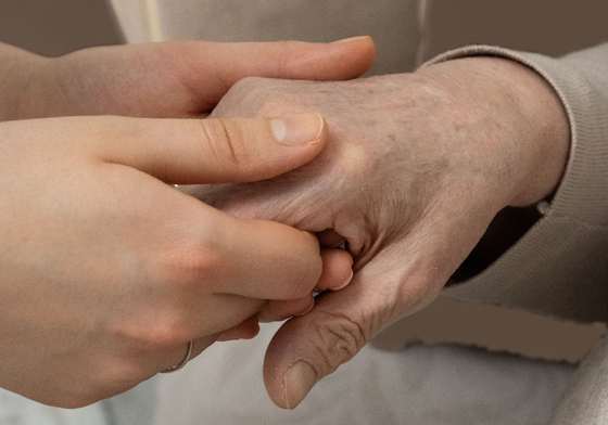 Junge Hände halten die Hand einer älteren Person